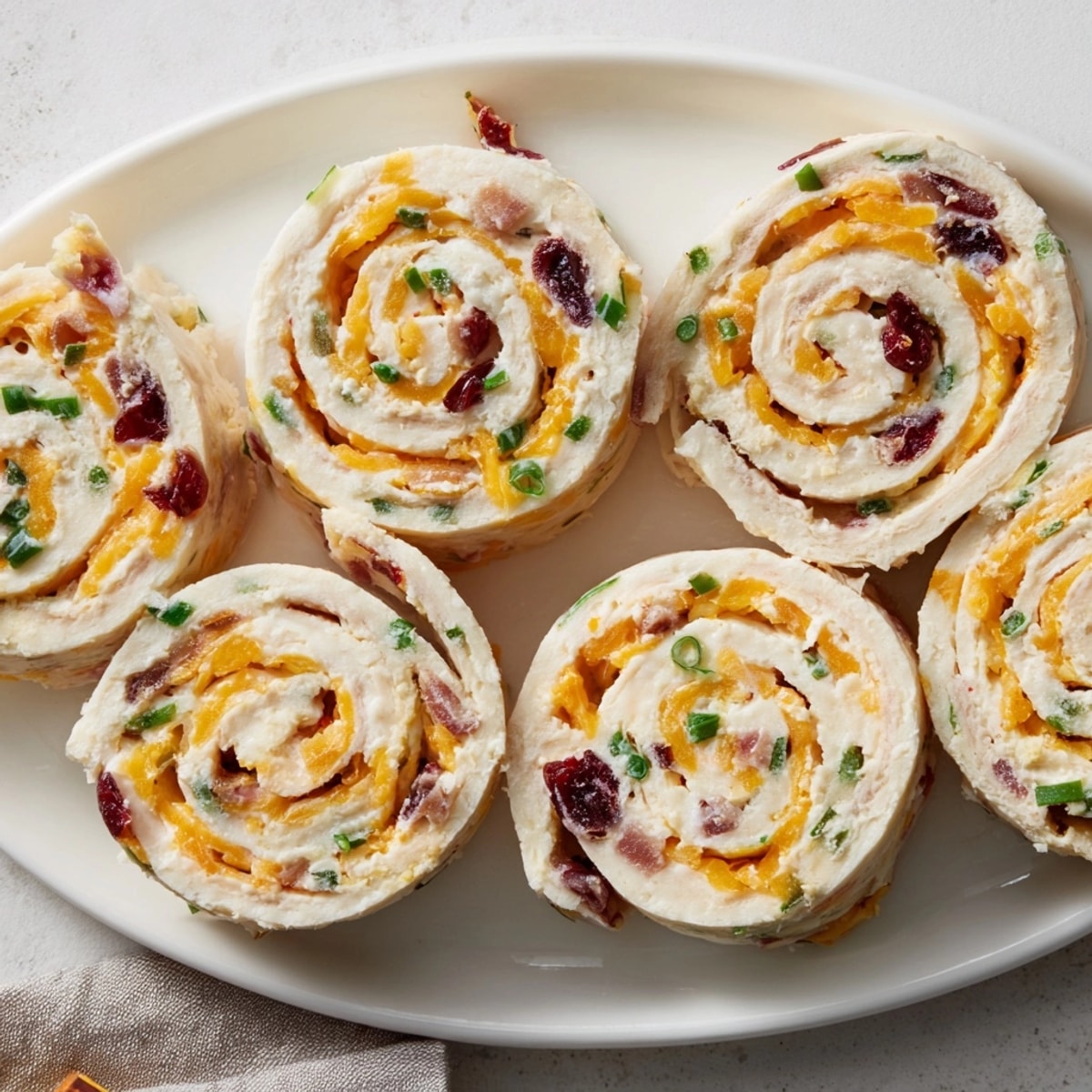 Tangy Cranberry Jalapeño Cream Cheese Pinwheels filling soft tortillas, ready to slice.