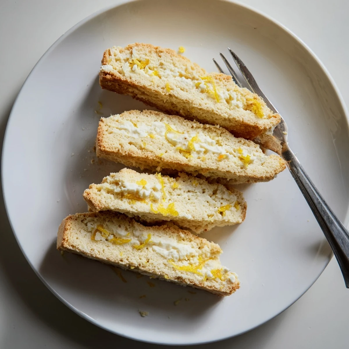 Crispy Ricotta Lemon Coconut Biscotti arranged on a rustic wooden board.  