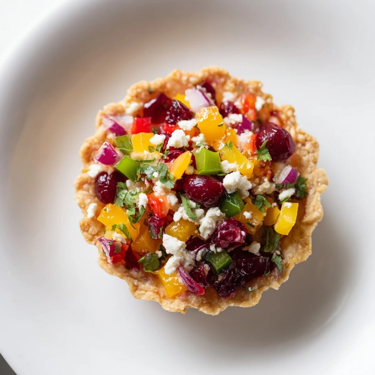 Colorful rainbow cranberry jalapeño tartlets topped with herbs, perfect for festive gatherings.