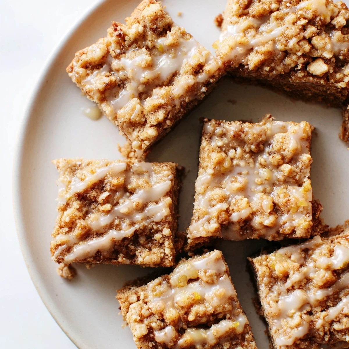 Enjoy a slice of homemade lemon-glazed gingerbread crumble bars, perfect for a cozy afternoon treat.