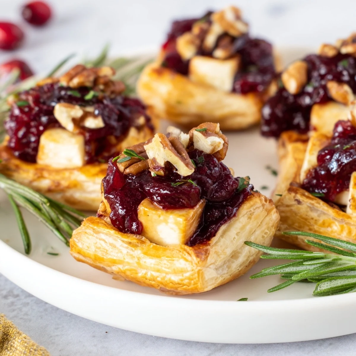 Warm, flaky puff pastry surrounds creamy Brie layered with sweet cranberry sauce in these Quick Cranberry Brie Bites.