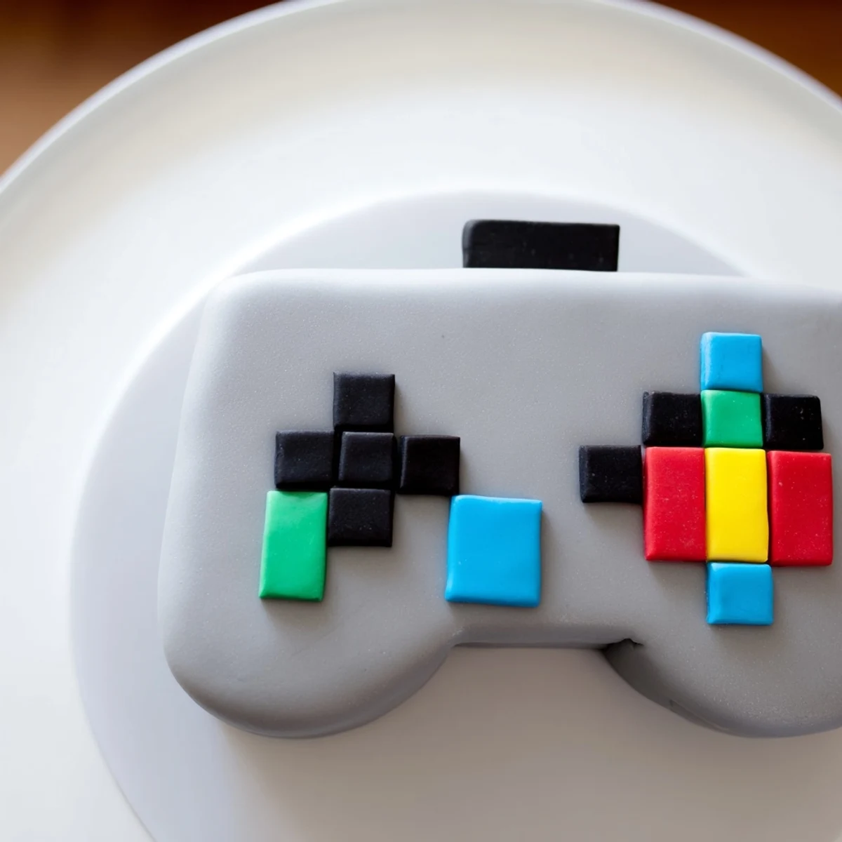 A close-up shot of the pixel video game controller cake, showing off detailed fondant pixel art.