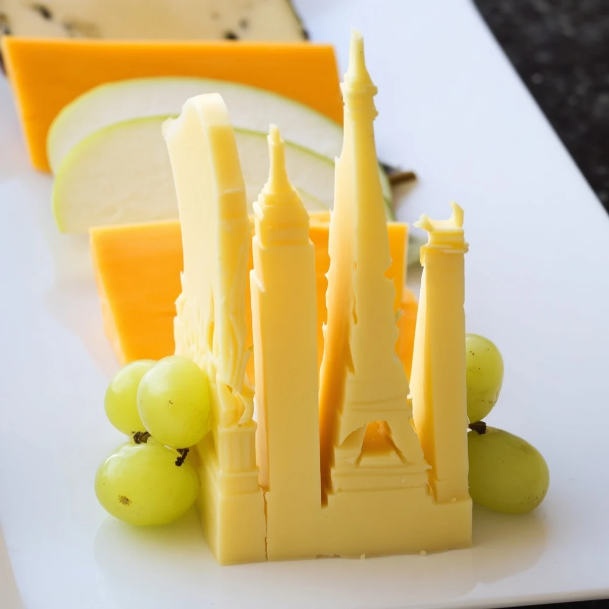 Skyline Silhouette cheese platter: architectural cheese slices with fresh fruit and crackers.
