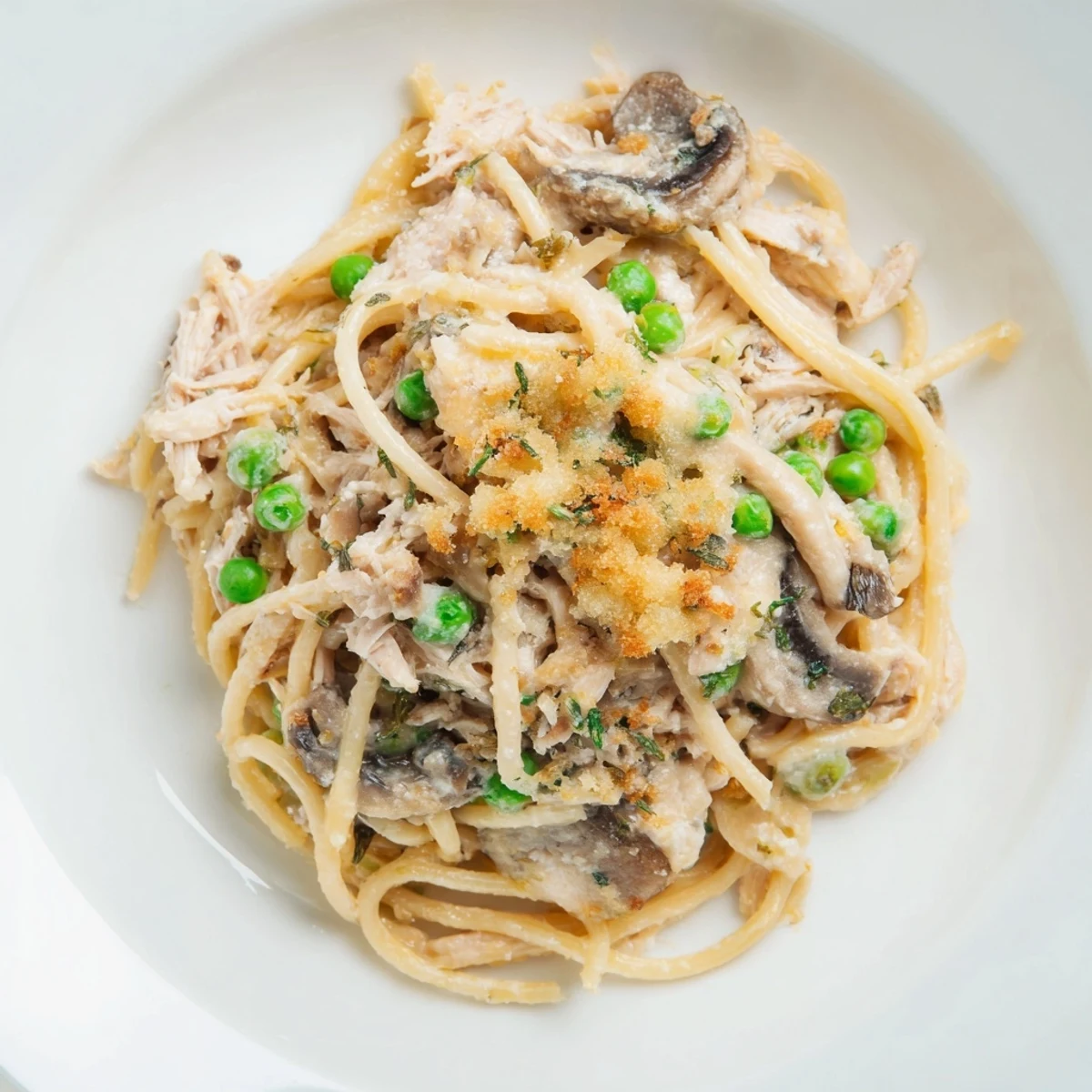 Creamy Turkey Tetrazzini with golden crust, tender pasta, and mushrooms bubbling in a casserole.