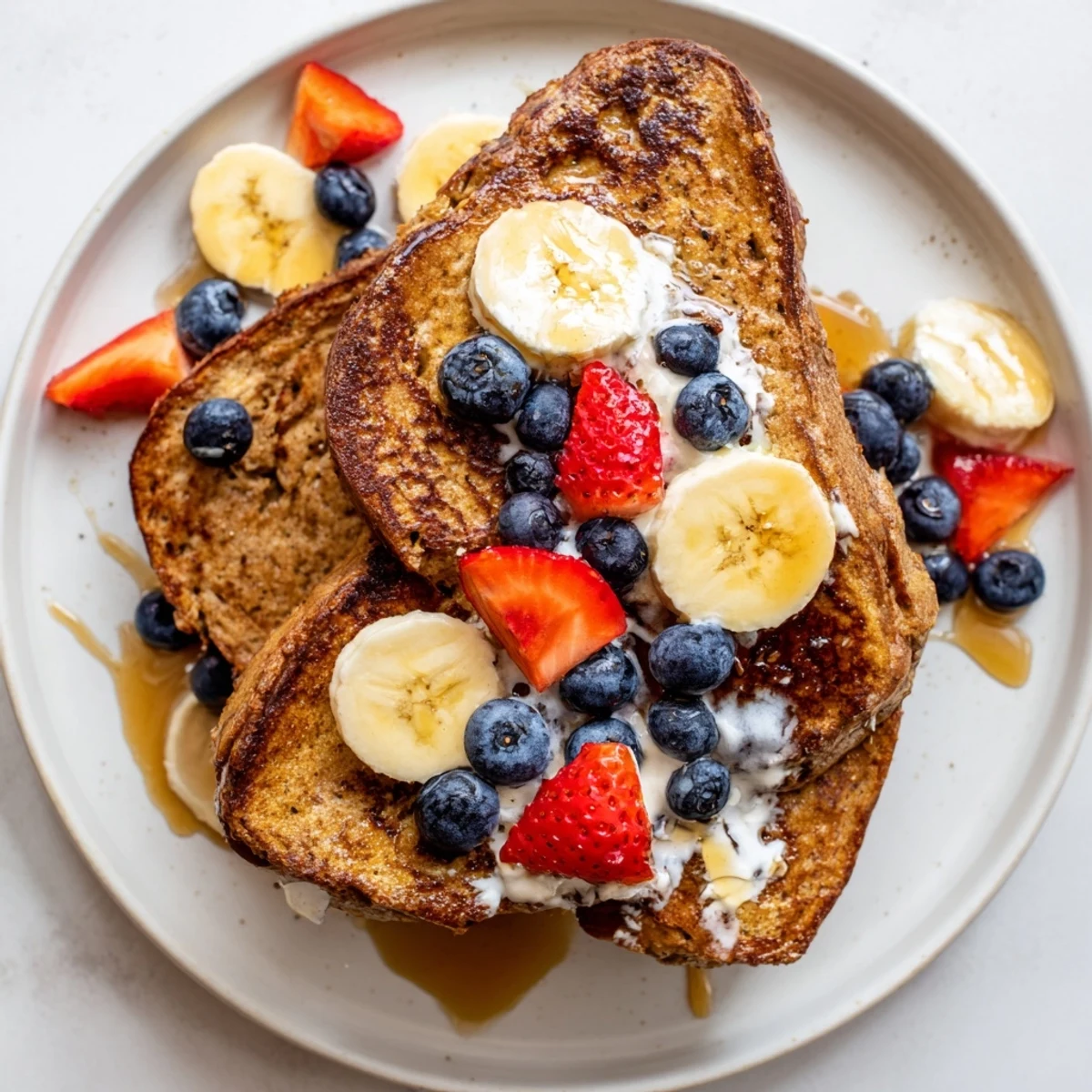 Fluffy protein French toast, golden brown, served with fresh berries and drizzled syrup.