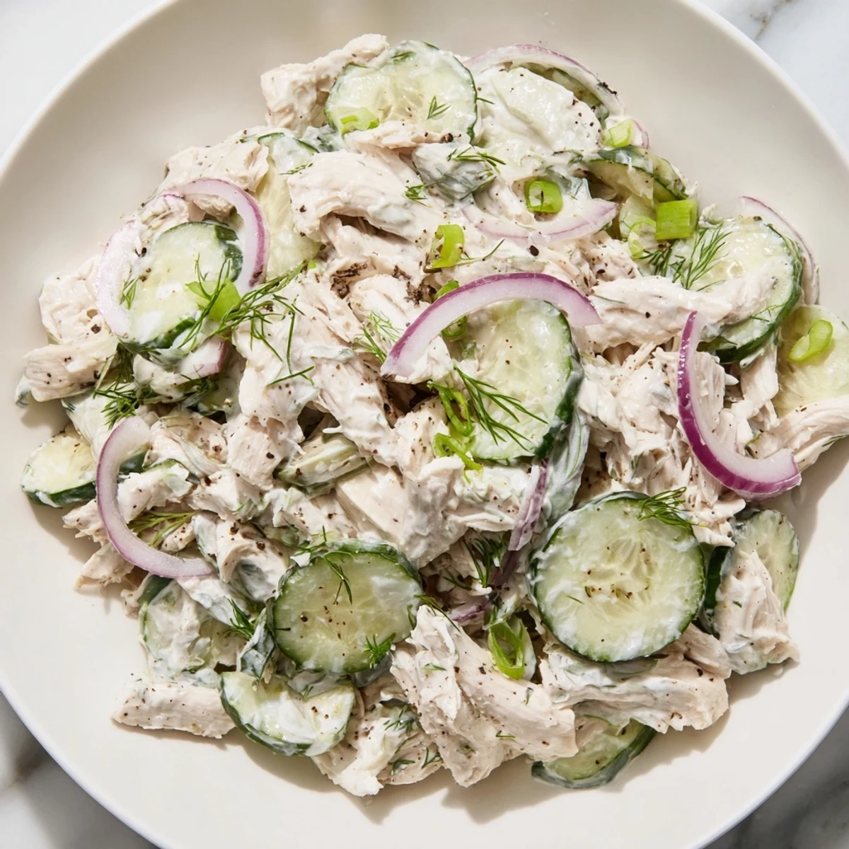 Enjoy a spoonful of cool and tangy Creamy Cucumber Chicken Salad, perfect for a light summer meal.