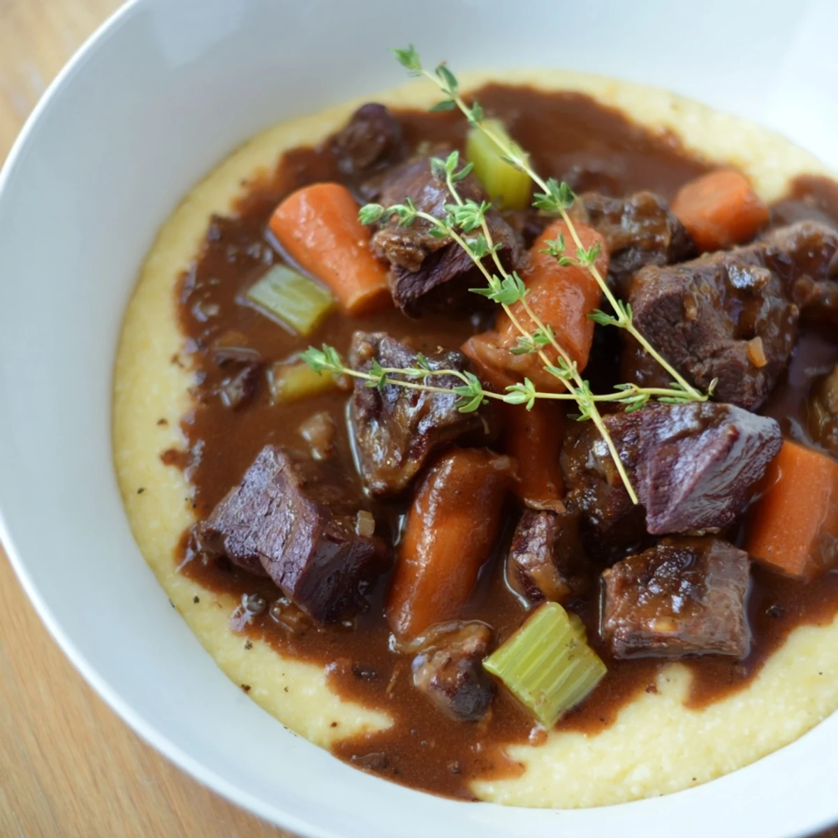 Overhead view of a comforting Venison Stew with Sloe Gin and Polenta served in a rustic bowl, showcasing the creamy polenta base.