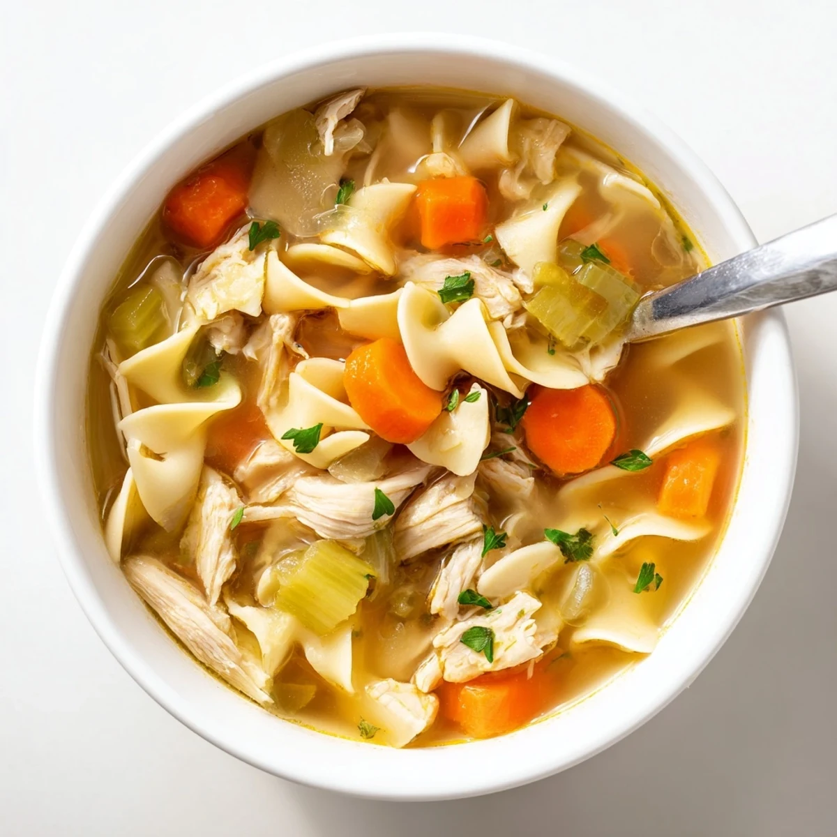 Homemade Instant Pot Chicken Noodle Soup featuring hearty vegetables, juicy chicken, and wide noodles in a clear, golden broth.