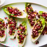 Close up of festive Cranberry Jalapeño Salsa Boats, endive leaves brimming with red relish.