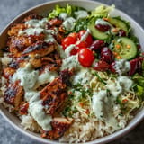 Vibrant chicken shawarma bowl, drizzled with creamy tahini, perfect for lunch.