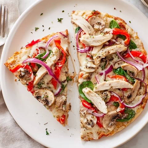 Creamy Alfredo Chicken Veggie Pizza topped with vibrant vegetables and melted cheese.  