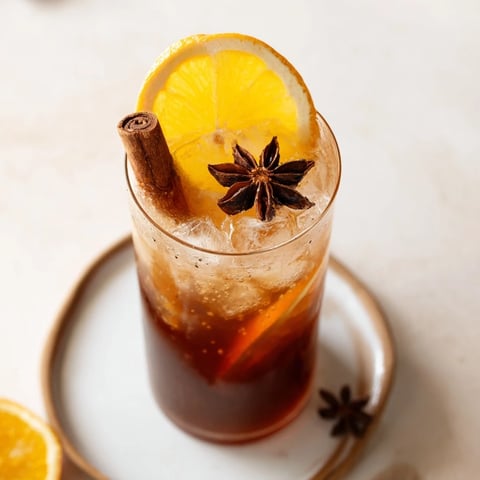 Cozy cinnamon-spiced chai fizz mocktail with fresh citrus and sparkling water.  
