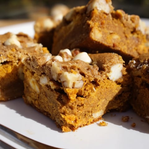 Indulge in Maple Bourbon Pumpkin Blondies, a warm, chewy treat with spices.  