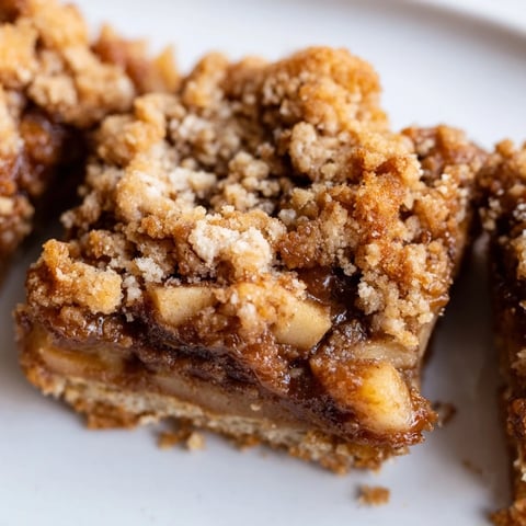 Chewy spiced caramel apple cookie bars topped with buttery crumble, perfect for fall.