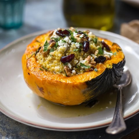 Roasted acorn squash stuffed with walnuts and cranberries, perfect for fall feasts.  