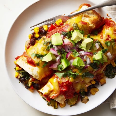 Sizzling black bean and veggie enchiladas topped with vibrant green salsa, utterly delicious. 