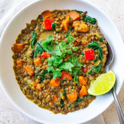 A steaming bowl of Coconut Curry Lentil Stew with Spinach, bursting with vibrant colors.  