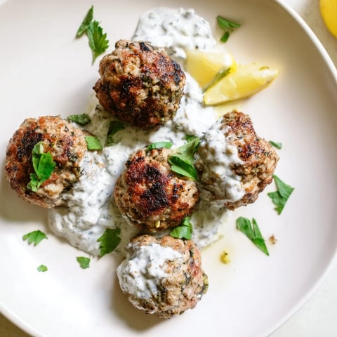 Juicy Garlic Herb Lamb Meatballs glistening, served with creamy zaatar yogurt, ready to eat.