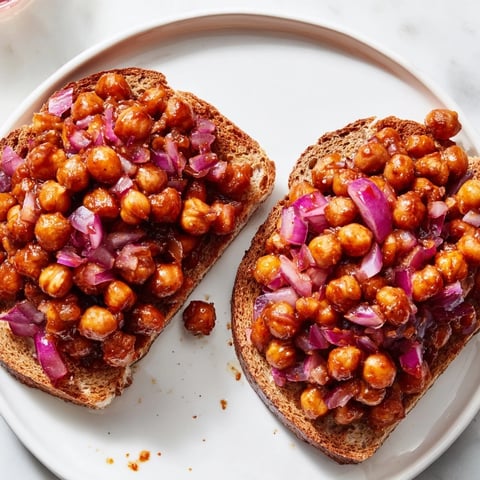 BBQ chickpeas on toast, with a vibrant BBQ sauce coating the tender chickpeas, ready to enjoy.