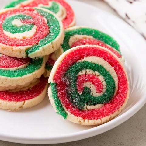 Golden-baked Holiday Pinwheel Cookies, swirled red and green, perfect for sharing at a festive gathering.