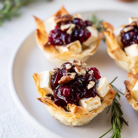 Golden cranberry brie bites, baked until bubbly, an easy appetizer perfect for festive occasions.
