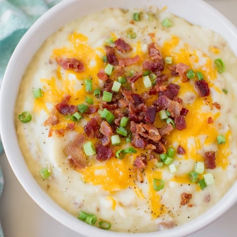 Warm Crockpot Loaded Baked Potato Soup, a creamy, cheese-filled delight, served with crumbled bacon.