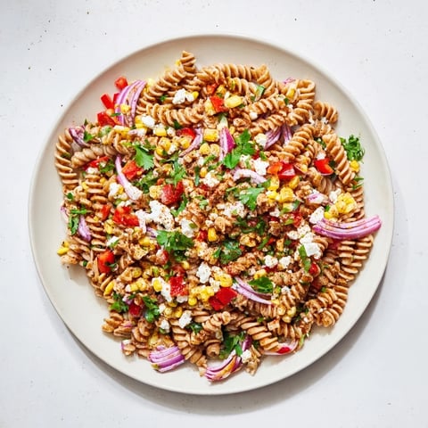 Healthier Mexican Street Corn Pasta Salad with charred corn, fresh lime, and creamy yogurt, ready to serve.