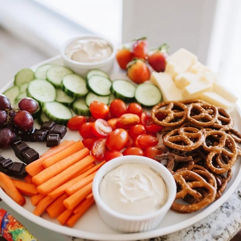 A colorful Fox & Friends snack tray overflowing with fresh, easy-to-grab vegetarian and savory treats.