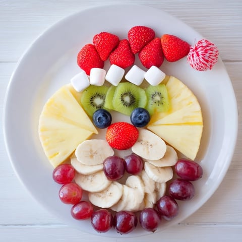 Santa Fruit Platter featuring vibrant pineapple beard and colorful fresh fruit, perfect for the holidays.