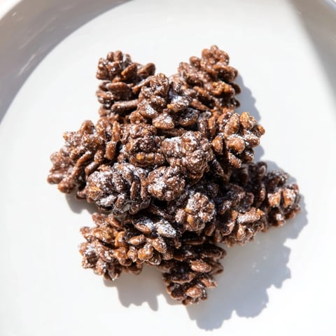 Delicious pinecone-shaped nut butter snacks coated in chocolate cereal, ready to eat.
