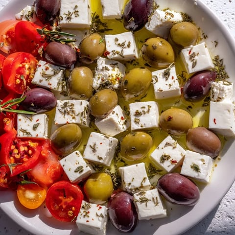 Holiday Mix: Mixed Olives with Feta Cubes, glistening with olive oil and spices, ready to enjoy.