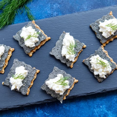 Appetizing arrangement of The Stormy Sea appetizer; grey crackers topped with creamy goat cheese.