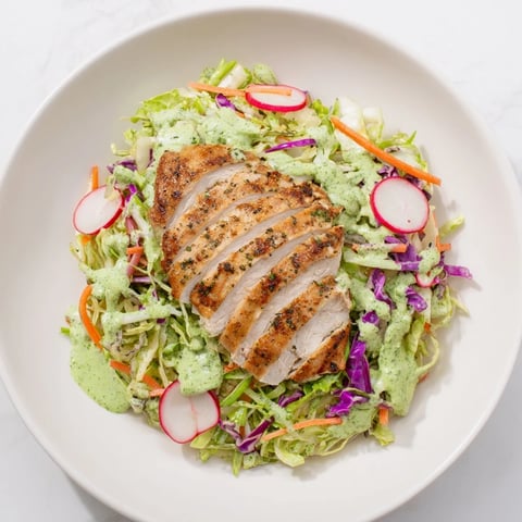 Green Goddess Cabbage Slaw with Grilled Chicken, a colorful, creamy slaw topped with grilled chicken slices.