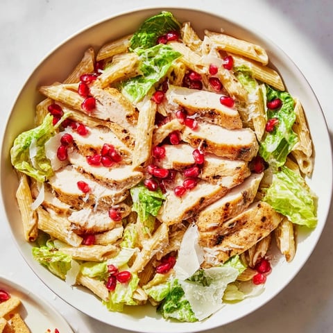 Creamy Chicken Caesar Pasta with pomegranate, a delightful dish with juicy chicken and fresh ingredients.