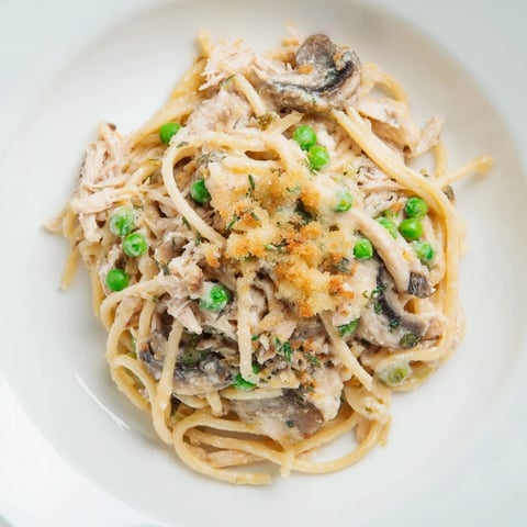 Creamy Turkey Tetrazzini with golden crust, tender pasta, and mushrooms bubbling in a casserole.
