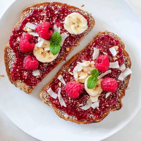 A close-up of vibrant raspberry chia jam toast, a delightful breakfast brimming with fresh berries.