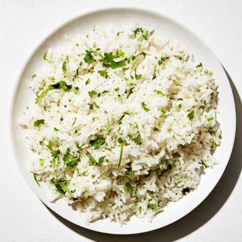 Steaming Cilantro Lime Rice, vibrant with herbs and citrus, ready to complement your tacos tonight.