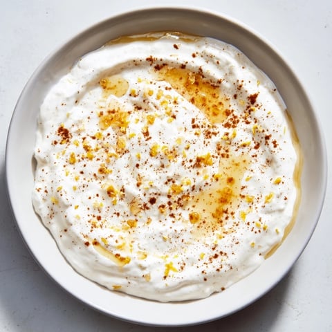 Creamy Greek Yogurt Fruit Dip, speckled with lemon, beckons with fresh apple slices and summer berries.