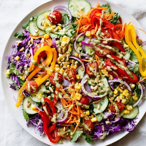 Rainbow salad with colorful vegetables and creamy tahini dressing, a vibrant light meal.