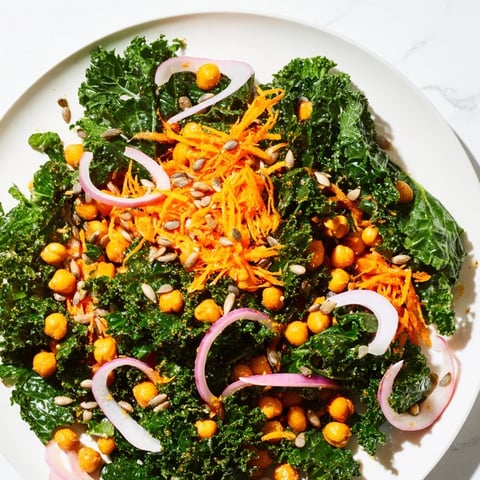 Vibrant kale salad with crispy roasted chickpeas, tossed and ready to eat with a tangy dressing.