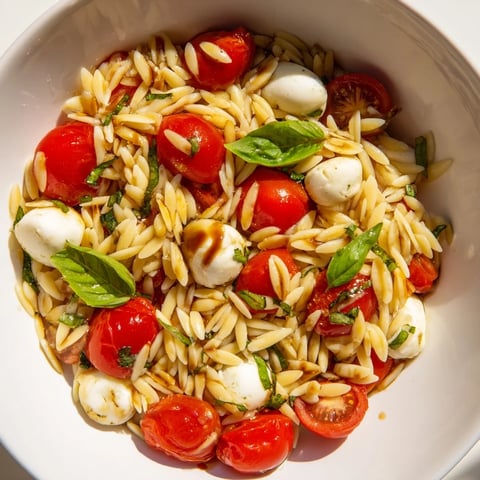 Bright, refreshing Caprese Orzo Salad featuring vibrant tomatoes, creamy mozzarella, and a tangy balsamic dressing.