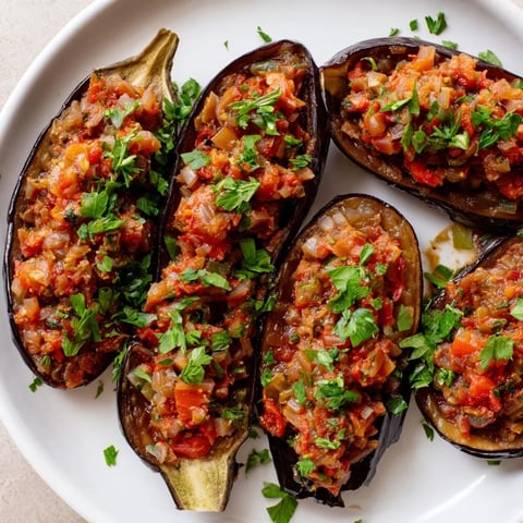 Image of vibrant, baked Imam Bayildi, a delicious Turkish eggplant dish overflowing with filling.