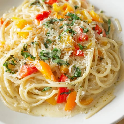 Creamy, vibrant roasted garlic pasta sauce drizzled with olive oil, ready for a comforting meal.