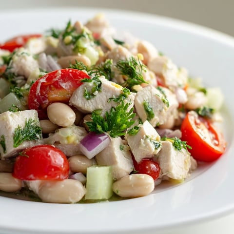 A vibrant bowl of Lemony White Bean Chicken Salad with fresh herbs and tomatoes.