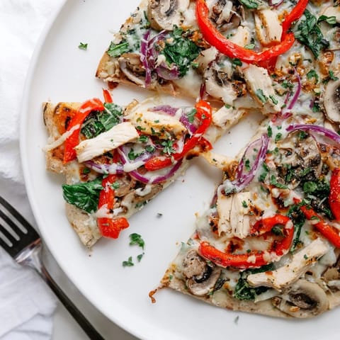 Golden crust of Alfredo Chicken Veggie Pizza, bursting with chicken and fresh peppers.  
