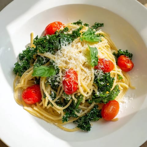 A close-up of the delicious one-pot spaghetti, featuring vibrant tomatoes and wilted kale, ready for dinner.