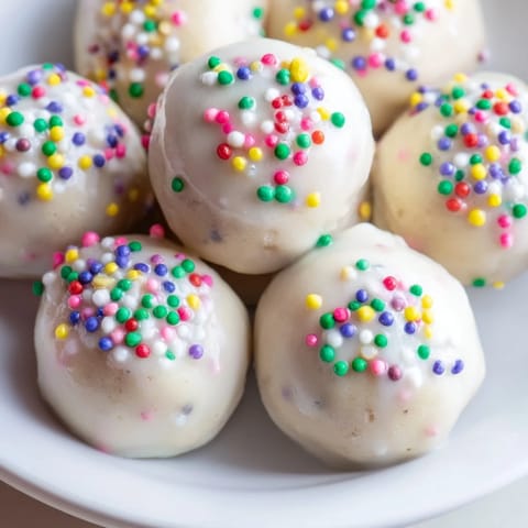 Close-up of frosted Protein-Packed Italian Christmas Cookie Balls, ready to enjoy with a warm beverage.