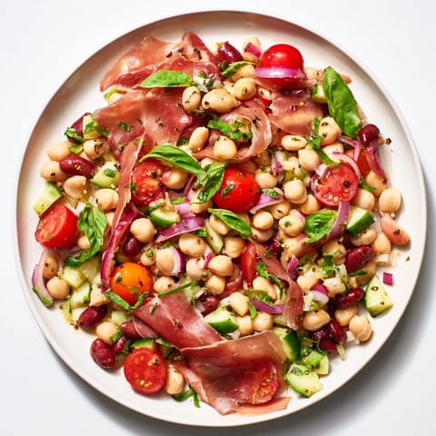 A hearty, gluten-free dense bean salad with prosciutto; imagine the colorful, refreshing ingredients tossed.