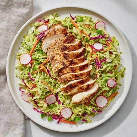 This Green Goddess Cabbage Slaw with Grilled Chicken features vibrant green dressing and tender grilled chicken.
