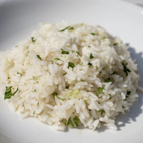 A bowl of fresh Cilantro Lime Rice, showcasing fluffy grains and pops of bright green cilantro.